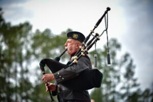 Man playing bagpipes outdoors, showcasing traditional Scottish music, in Spring Lake, NC.