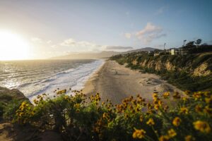 Captivating view of Malibu beach at sunset with waves and cliffs in California, USA.
