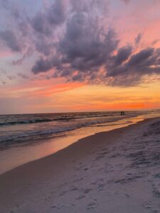 Vibrant sunset over Panama City Beach with dramatic skies and serene waves.
